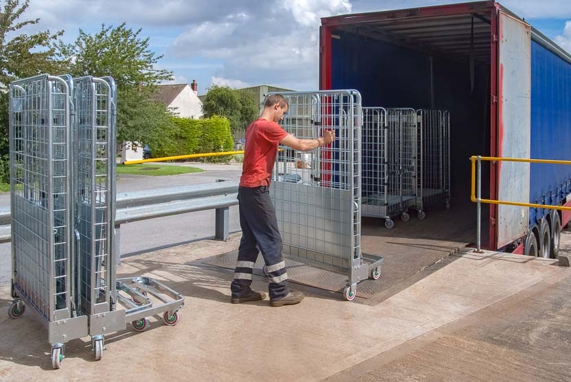 An employee loads rented roll container containers into a truck semi-trailer